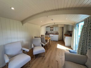Un espace de vie compact comprenant un coin repas, une cuisine et un espace détente.
