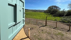 A light blue building with a view of a green field and hills. - The Orchard (Dorchester)