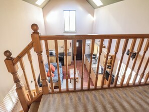 Una escalera de madera con vistas a un dormitorio y una cocina.
