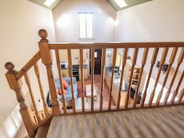 Una escalera de madera con vistas a un dormitorio y una cocina.