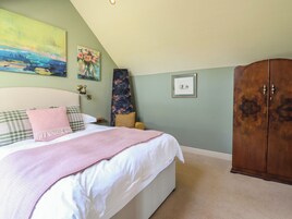 Un dormitorio con una cama, un armario y un cuadro en la pared.