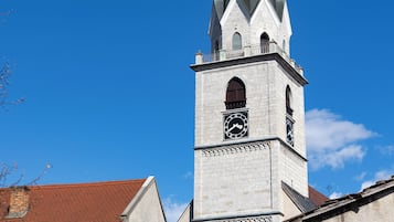 A church with a pointed steeple, a clock, and a weather vane.