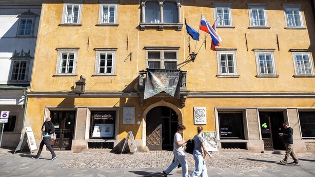 A building with multiple windows, a flag, and a banner. - Old Town Guest Accommodation (Kranj)