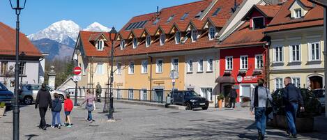 A cobblestone street with buildings, a stop sign, and a mountain in the background.