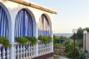 A building with three arched windows, a balcony with white balustrades, and a view of the sea. - Shared gardened accommodation with bbq and sea view (Zambratija)