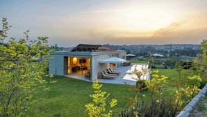 Una casa moderna con patio, piscina e vista sulla città.