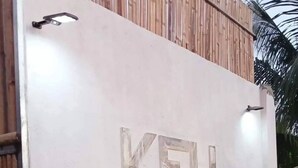 A building with a sign reading 'KFH VILLA' and a wooden fence above.