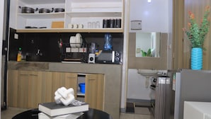 Cocina moderna con microondas, tostadora y cafetera en la encimera, un lavabo y un refrigerador.