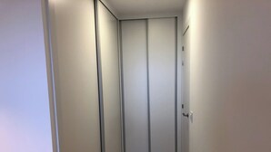 Un couloir étroit, avec une porte coulissante au fond.