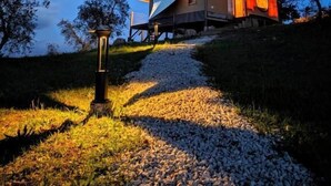 A modern house with a sloped roof, a visible door, and a pathway leading to it. - Glamping Stregaia (Massa Marittima)