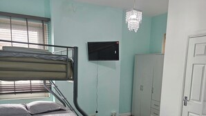 A bunk bed with a TV mounted on the wall, a wardrobe, and a chandelier. - M4 Victoria Hub 5 (Newport)