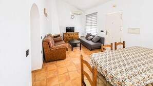 Une pièce comprenant un canapé, un téléviseur, une table à manger et un lit.