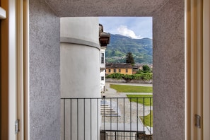 Un balcon avec vue sur une montagne et un immeuble.