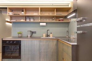Een moderne keuken met houten keukenkastjes, een inbouwoven en een roestvrijstalen koelkast.