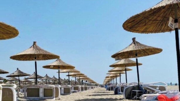 A beach with rows of sun umbrellas and lounge chairs. - Enjoyable 1-bedroom chalet with AC in charming Hamallaj (Hamallaj)