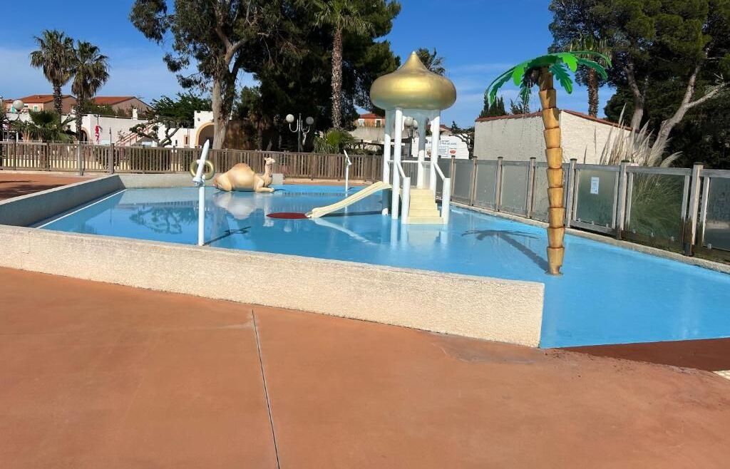 A swimming pool with a slide and a small structure with a golden dome.