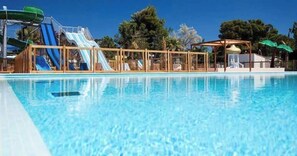 Una piscina al aire libre de temporada, sombrillas