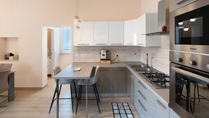 A modern kitchen with a central island, bar stools, and a dining area. - Apartment 'Diegopas' with Sea View, Wi-Fi and Air Conditioning (Sant'Antonio Abate)
