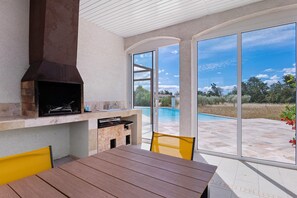 An outdoor patio with a grill, a table, and chairs. - “Domaine des Lucques” Guest Room with Private Pool, Wi-Fi, and Air Conditioning (Mirepeisset)