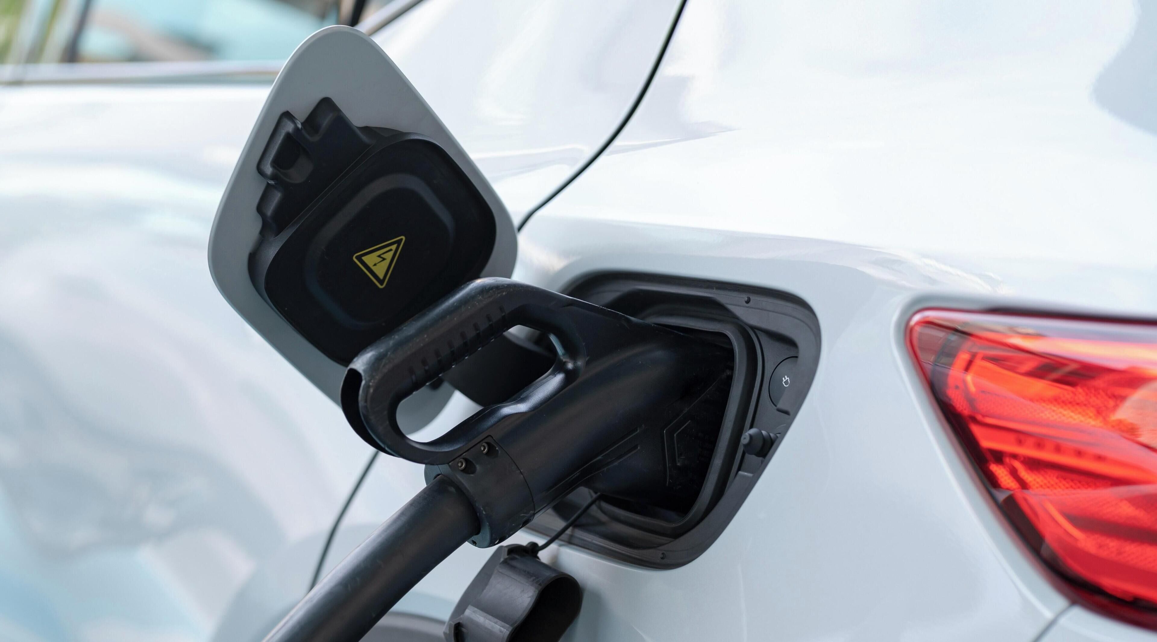 A car charging station with a triangular warning symbol.