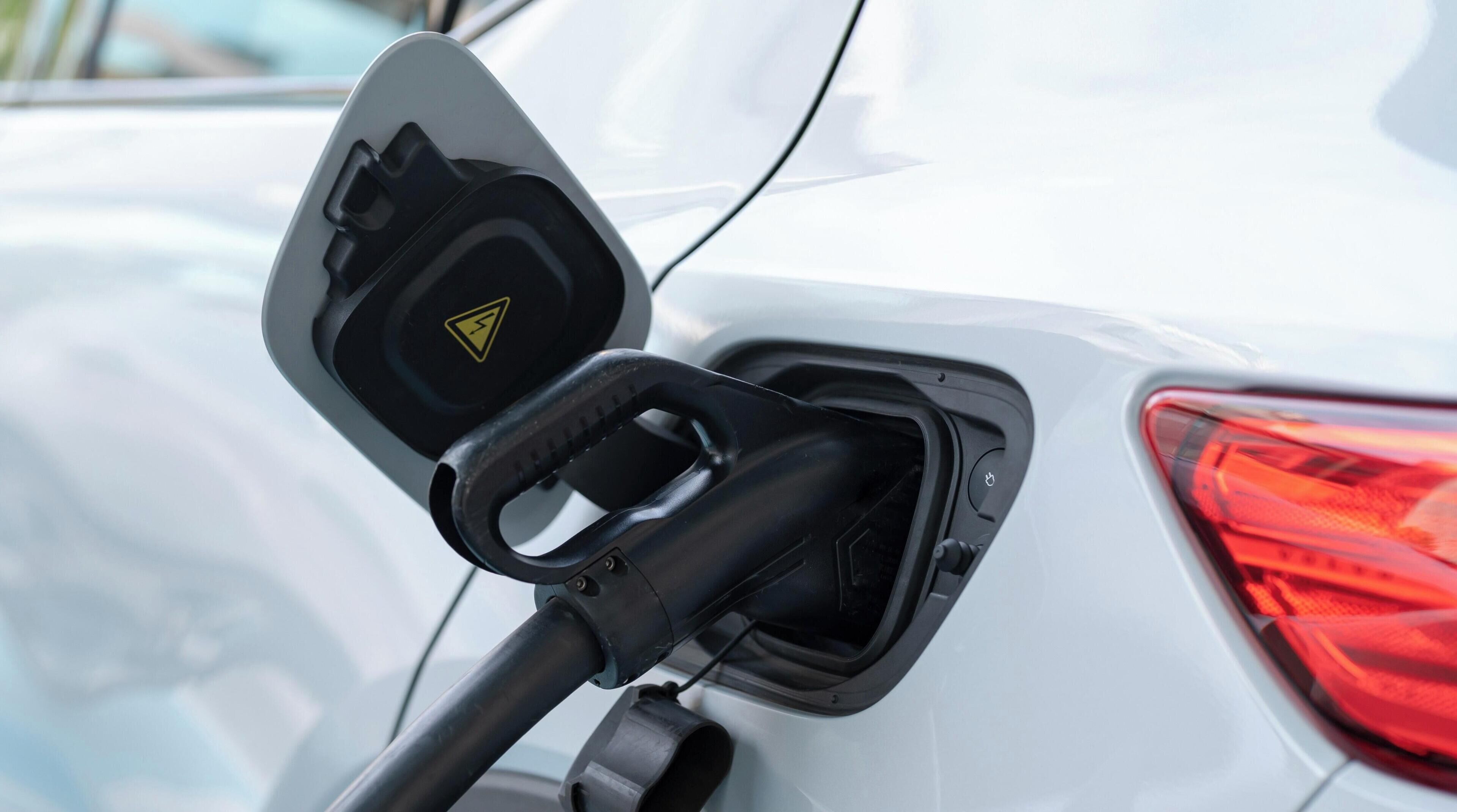 A car charging station with a triangular warning symbol.