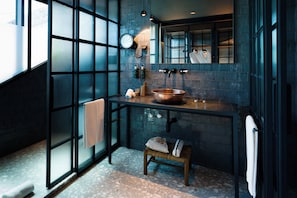 Une salle de bain moderne avec une grande fenêtre, un lavabo en cuivre et un porte-serviettes.