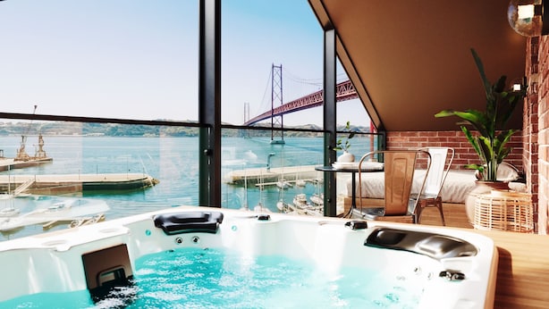 A hot tub with a view of a bridge, a table with chairs, and a potted plant. - Docas Hotel Lisbon (Lisbon)