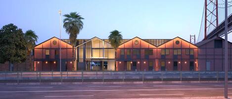 A hotel with a modern architectural design, featuring a prominent entrance and a brick facade.