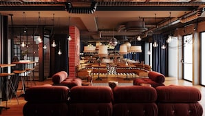 A modern interior with a central seating area, exposed ductwork, and hanging pendant lights. - Docas Hotel Lisbon (Lisbon)