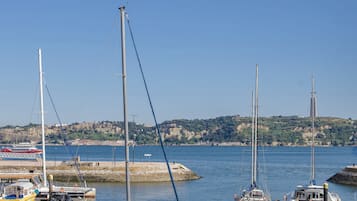 A marina with boats docked, a clear sky, and a hilly landscape in the background.