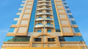 A tall building with a sign for 'SHARAH ROYAL TULIP LLC' at the bottom.