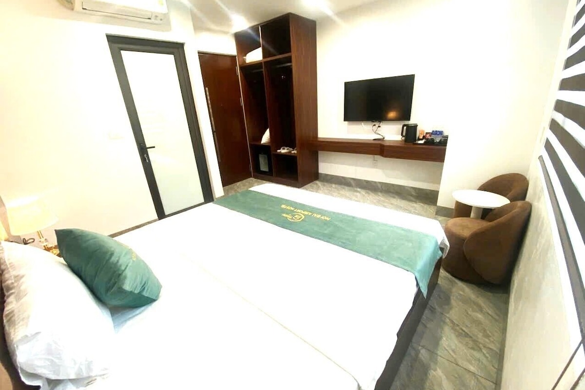 Una habitación de hotel con cama, televisión, escritorio y zona de estar.