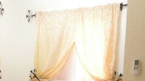 Ein Schlafzimmer mit Bett, Vorhängen, Nachttisch und Teppich.