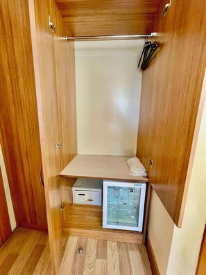 Een houten garderobe met kledingroede, een klein legplankje en een geïntegreerde kluis.