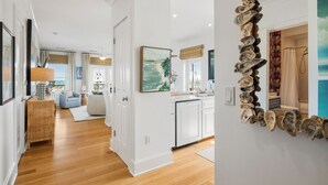 A modern interior with a wooden floor, white walls, a dining area, and a kitchen.