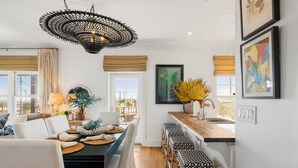 A modern kitchen with a dining area, wooden countertops, and a hanging light fixture.
