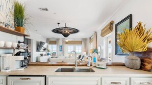 A modern kitchen with a central island, built-in appliances, and a large window.