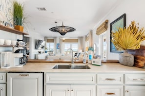 A modern kitchen with a central island, built-in appliances, and a large window. - **Brand New to rental market**Sea Salt & Ivy, 3 BR 2 Bath Condo on SGI, Elevator, Dog Friendly 266 steps to the beach... (St. George Island)
