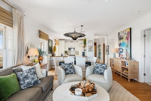 A modern living room with a sofa, armchairs, a coffee table, and a dining area in the background. - **Brand New to rental market**Sea Salt & Ivy, 3 BR 2 Bath Condo on SGI, Elevator, Dog Friendly 266 steps to the beach... (St. George Island)