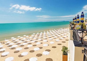 A beach with numerous white umbrellas and a clear view of the sea. - Sea view & Beach Apartment (Nessebur)