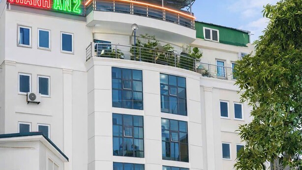 Un edificio de varios pisos con un letrero que dice 'THANH AN2' y 'KHACH SAN THANH AN2'.