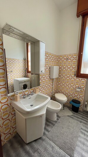 A bathroom with a sink, toilet, bidet, and a mirror. - Gabri House (Speranza)