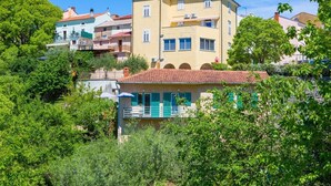 A multi-story building with balconies, surrounded by greenery. - Apartment Bijenica - surrounded by lush greenery (Vrbnik)
