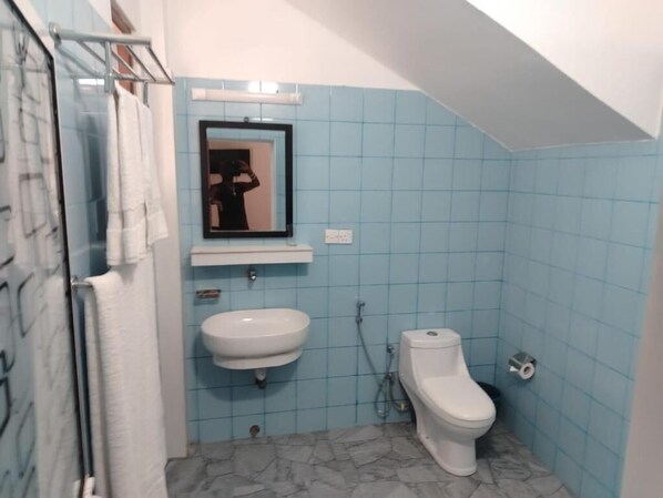 Un baño con lavamanos, inodoro y espejo.