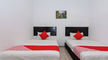 Een hotelkamer met twee bedden, wit beddengoed, rode accenten en een klein schilderij aan de muur.