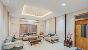 Una sala de estar moderna con un conjunto de sofás, una mesa de centro y un ventilador de techo.