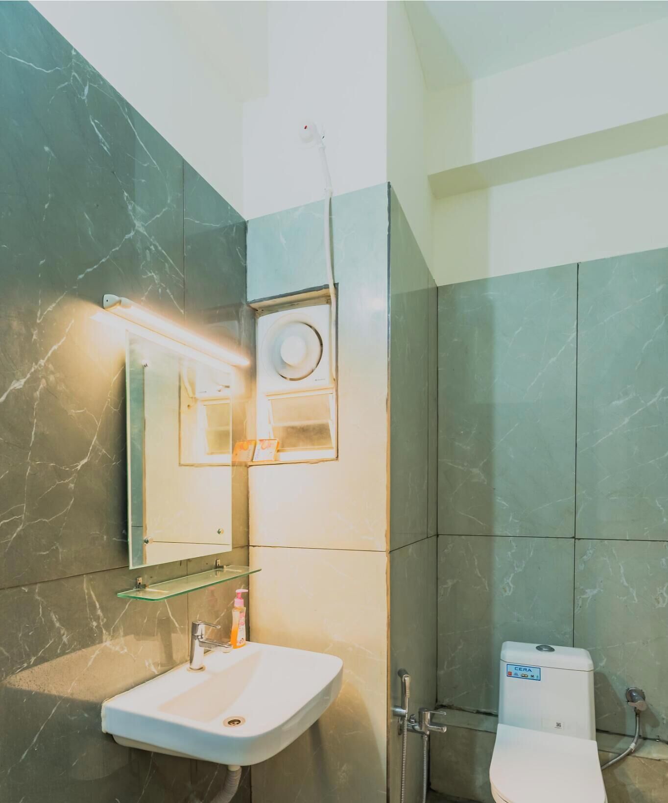 A bathroom with a white sink, a mirror, a toilet, and a shower.