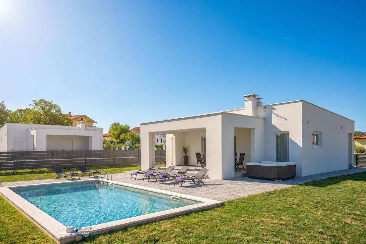 Una casa moderna con piscina, sillones de descanso y un jacuzzi.