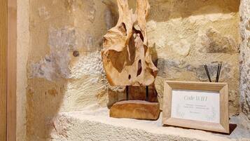 Ein Holzschild mit der Aufschrift 'Code WIFI' und 'Bienvenue 28' an einer Steinwand.