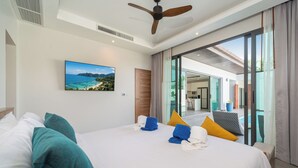 A hotel room with a bed, a ceiling fan, a painting of a beach, and a view of the outside. - Nicky Serene 3BR Pool Villa (Choeng Thale)